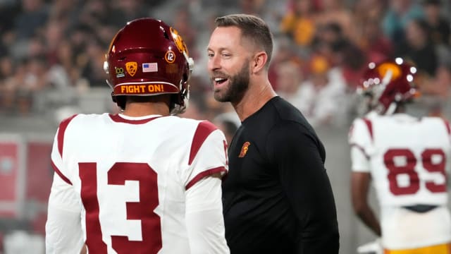 The former Arizona Cardinals head coach and now USC Trojans assistant coach Kliff Kingsbury talks to quarterback Caleb Williams (13) during the pregame warmup before playing the Arizona State Sun Devils at Mountain America Stadium in Tempe on Sept. 23, 2023.